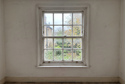 Old white painted timber double hung sash window seen from inside a heritage home